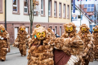 Narrenumzug adlı Masquerade Festivali baykuşları. Fasnacht, Almanya 'da yer alan bir karnavaldır. Olay her yıl olur. Almanlar için eski bir gelenektir. İnsanlar ürkütücü maskeler ve elbiseler giyer..