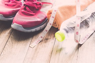 Spor ayakkabı, havlu, su, ahşap zemin üzerinde şerit metre