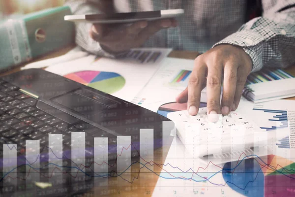 Hesap makinesi ve tablet üzerinde çalışan iş adamı.