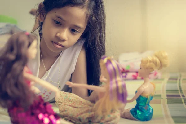 Κοριτσάκι παίζει κούκλες στο κρεβάτι. — Φωτογραφία Αρχείου