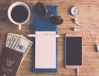 Defter, kalem, güneş gözlüğü, kahve fincanı, pasaport, para, mobil P