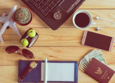 Laptop, defter, kalem, güneş gözlüğü, kahve fincanı, passp, üstten görünüm