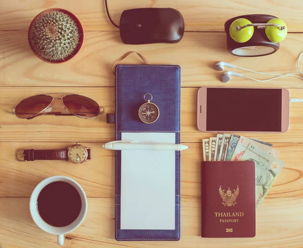 Vista superior del portátil, pluma, gafas de sol, taza de café, pasaporte, mon — Foto de Stock