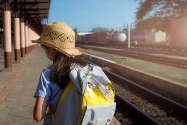 Bir trenin tren istasyonunda bekleyen genç kız.
