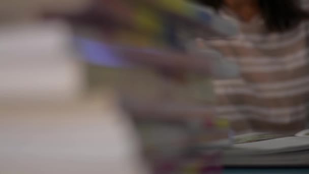 Fille retourner une page et la lecture d'un manuel avec pile de livres sur la table à la maison. Concept d'éducation. Plan panoramique .