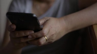 Kadın eli kapalı cep telefonundan mesaj göndererek iletişim kurmak ve sosyal medyada yatak odasında sohbet etmek istiyor..