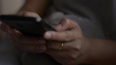 Kadın eli kapalı cep telefonundan mesaj göndererek iletişim kurmak ve sosyal medyada yatak odasında sohbet etmek istiyor..