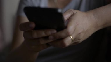 Kadın eli kapalı cep telefonundan mesaj göndererek iletişim kurmak ve sosyal medyada yatak odasında sohbet etmek istiyor..