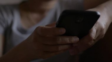 Kadın eli kapalı cep telefonundan mesaj göndererek iletişim kurmak ve sosyal medyada yatak odasında sohbet etmek istiyor..
