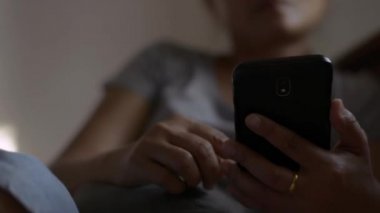 Sosyal güvenlik için cep telefonu kullanan kadın ellerini kapat. Yatakta akıllı telefonuyla sosyal uygulamaları kontrol eden Asyalı bir kadın. Kablosuz teknoloji kavramı.