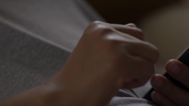 Fermer les mains de la femme en utilisant le téléphone mobile pour les réseaux sociaux. Femme asiatique vérifiant les applications sociales avec smartphone sur le lit. Concept de technologie sans fil .