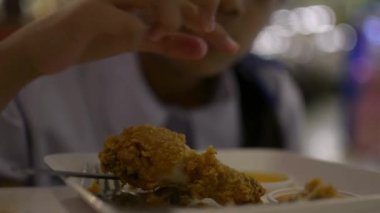 Öğle yemeği sırasında kafeteryada kızartılmış tavuk ve patates yiyen tatlı bir kız öğrenci..