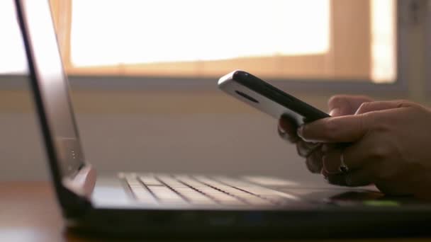 女性の手は コミュニケーションのためのスマートフォンを使用して作業机の上でソーシャルオンラインとチャット 家からの仕事 — ストック動画