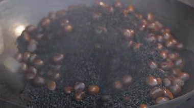 Kestane tohumları kızartma tavasında pişiriliyor. Tayland 'da ikonik yiyecekler.