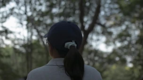 キャップを身に着けている若い美しい女性は プーケットのマングローブ林の通路を歩いています リアビューフォローショット — ストック動画