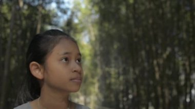 Asyalı tatlı kız gün ışığı altında mangrov ormanlarının arasında yürüyor. Genç bayan çocuklar tropikal yağmur ormanlarında güzel manzaraları izliyorlar. Yavaş çekim.