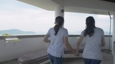 Anne ve kızı günlük kıyafetlerini giyip Manzara Kulesi 'ne akın ediyorlar ve Phuket Koyu' nun üzerindeki büyüleyici manzaranın keyfini çıkarıyorlar. Anne ve kızı mutlu bir şekilde kollarını havaya kaldırıyor.. 