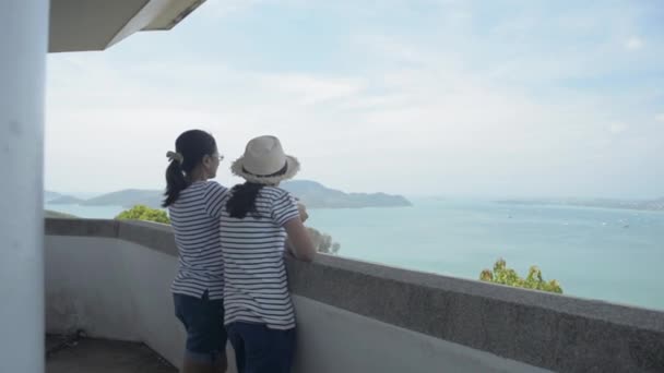 母と娘はビューポイントタワーに立って 夏の間の午前中に湾の美しい景色を見ています — ストック動画