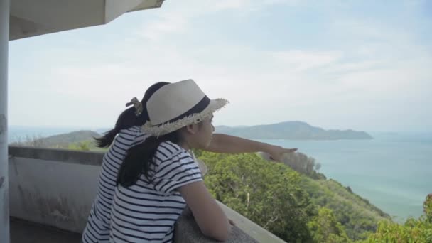 母と娘はビューポイントタワーに立って 夏の間の午前中に湾の美しい景色を見ています — ストック動画