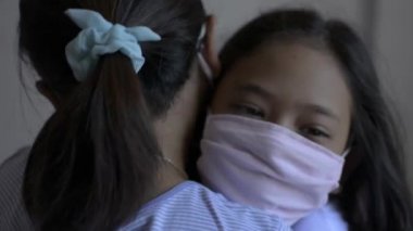 Anne ve kızı Covic 19 salgını sırasında birbirlerine sarılıp koruyucu maske takıyorlardı. Corona virüs koruması. Sağlıklı ve güvenli yaşam kavramı. Aşkın ifadesi.