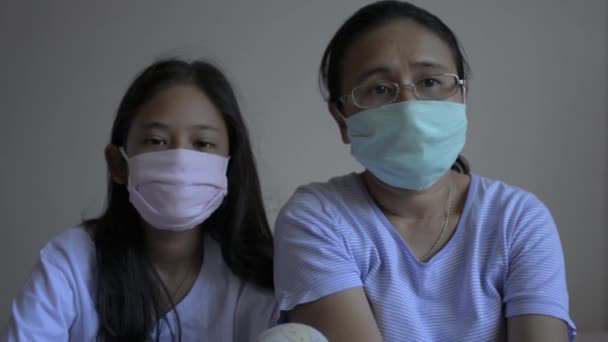 母親と娘は コロナウイルスから身を守り 家に一緒にいるために保護マスクを着用しています 健康と安全のライフコンセプト コヴィッド19発生 — ストック動画