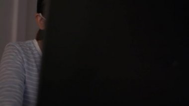 Koruyucu maske takan bir kadın evde dizüstü bilgisayarla masada çalışıyor. Coronavirus koruması. COVID-19 salgını. Sağlıklı ve güvenli yaşam kavramı. Evden çalışıyorum. Döndürme çekimi.