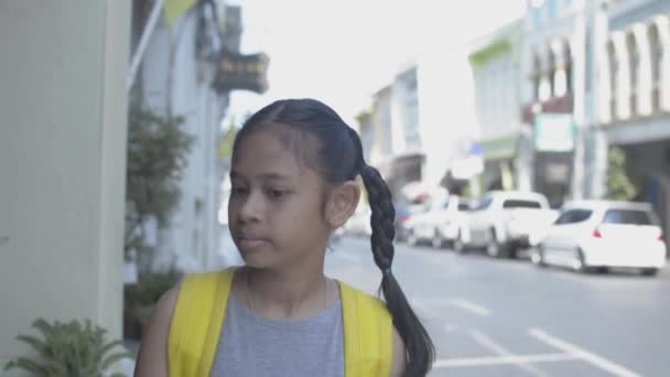 夏の間にプーケットのコロニースタイルの建物の間の歩道をゆっくりと歩いてバックパックを持つアジアの女の子 スローモーション — ストック動画