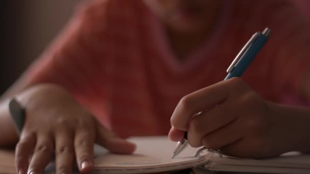 紧紧地握住一个在笔记本上写字的小女孩的手 女学生在日记上记笔记 用写作材料做作业 教育概念 — 图库视频影像