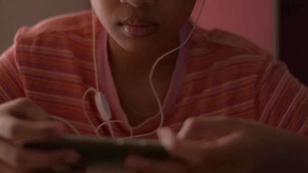 Niña Asiática Usando Teléfono Móvil Con Auriculares Mientras Los Medios — Vídeo de stock