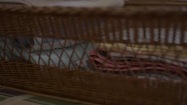 女人在折叠衣服 放进木篮里 家庭主妇在卧室做一些家务活 把一堆叠好的衣服放在床上 — 图库视频影像