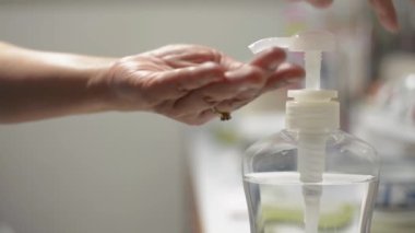 COVID-19 salgını sırasında ellerini alkol jeliyle temizleyen bir kadın. Ev hanımı virüs yayılmasını önlemek için el temizleme jeli kullanıyor. Coronavirus koruması. 
