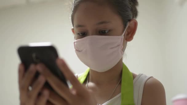 Menina Bonito Asiático Avental Usando Máscara Protetora Usando Telefone Celular — Vídeo de Stock