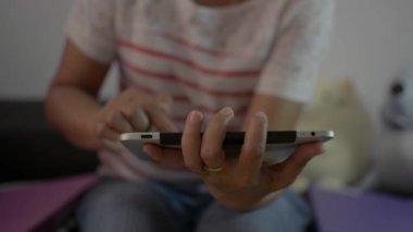 Oturma odasında oturup dijital tablet kullanan bir kadın sosyal medyayı evde izliyor. Covid-19 durumu sırasında veri takibi ve haberleşme cihazı ile günlük haberler. Evden çalış..