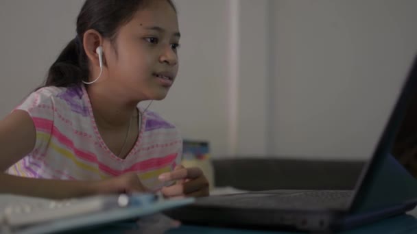 온라인 학습을 이어폰을 선생님 이야기를 나누는 아시아의 귀여운 여학생 Covid — 비디오