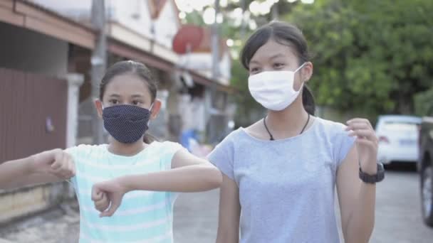 两名戴着防护面罩的可爱的亚洲女孩站在住宅区的小径上 喜欢跳可爱的舞步 女青少年在住宅区度假期间的活动 — 图库视频影像
