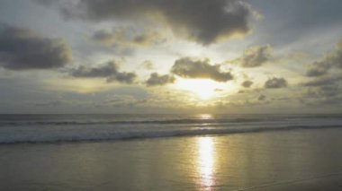 Gün batımında Pofet 'te çarpıcı gökyüzü olan çarpıcı bir plaj. Akşamları kumlu sahilde dalgalar sıçrıyor. Güneş ışığı, Karon sahilindeki deniz suyunun yüzeyine yansımaktadır. Tayland.