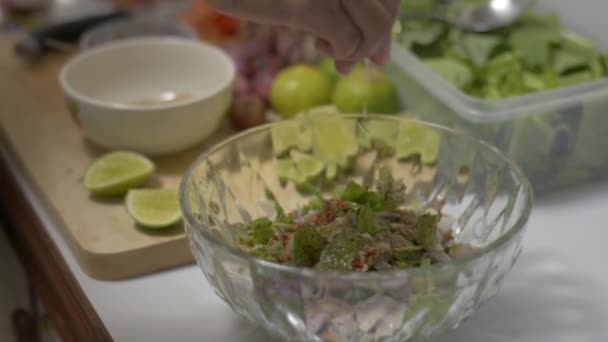 家庭主妇挤榨柠檬汁 然后用勺子和叉子把所有的配料混合在一个大碗里 厨房里准备辣鸡肉沙拉的女人的手 — 图库视频影像