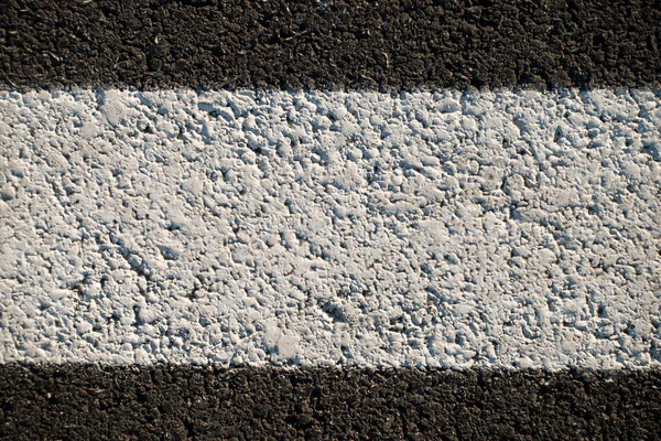 Abstract texture of a asphalt road with white paint on it — Stock Photo, Image