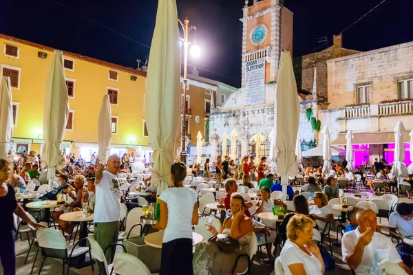 Mucha gente, turistas, en Zadar durante las noches de verano — Foto de Stock