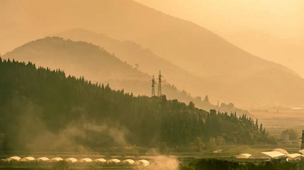 远山在肥沃的田地，在日落时后面 — 图库照片