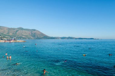 Kupari, Hırvatistan - 5 Ağustos 2016: Kupari, Dubrovnik yakınlarında insanların turkuaz suda yıkandığı ve kumlu sahilde güneşlendiği bir yer