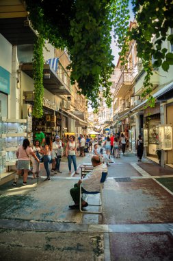 Tourists and local Greeks shop at the outdoor shopping center and marketplace near the Monastraki and Plaka district in Athens Greece clipart