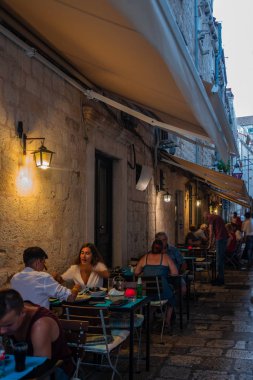People at street cafe with lantern illuminated at night in Dubrovnik, Croatia