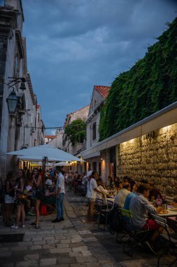 People at street cafe with lantern illuminated at night in Dubrovnik, Croatia