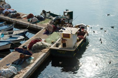 Limandaki ağlar üzerinde çalışan balıkçılar.