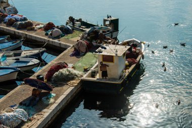Limandaki ağlar üzerinde çalışan balıkçılar.