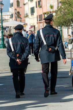 two italian cops called Carabinieri Walking along the Canale Grande clipart