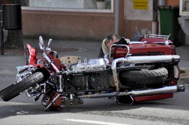Harley Davidson 'ını parçaladıktan sonra motosikletinin yanında duran adam.