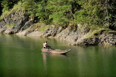 Etrafı dağlarla çevrili güzel bir dağ gölü. İnanılmaz sihirli mavi göl ve balıkçı teknesi