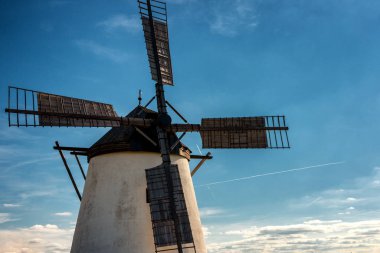 Arkasında mavi gökyüzü ve bulutlar olan tarihi yel değirmeninin ayrıntıları.